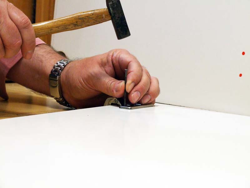 Using a small nail to guide the drill bit