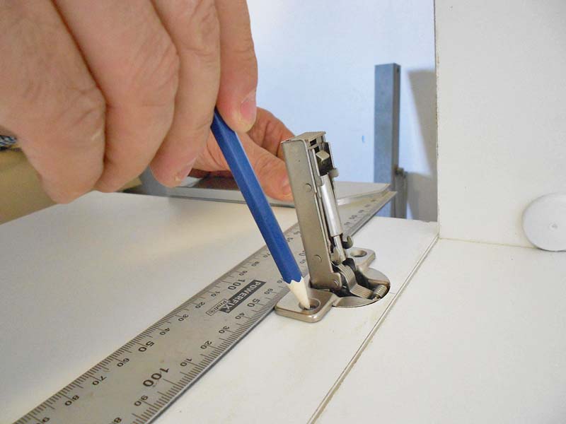 Using a pencil we mark the position of the hinge fixing holes