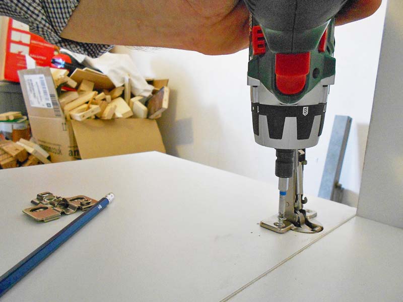 We screw the hinge to the door