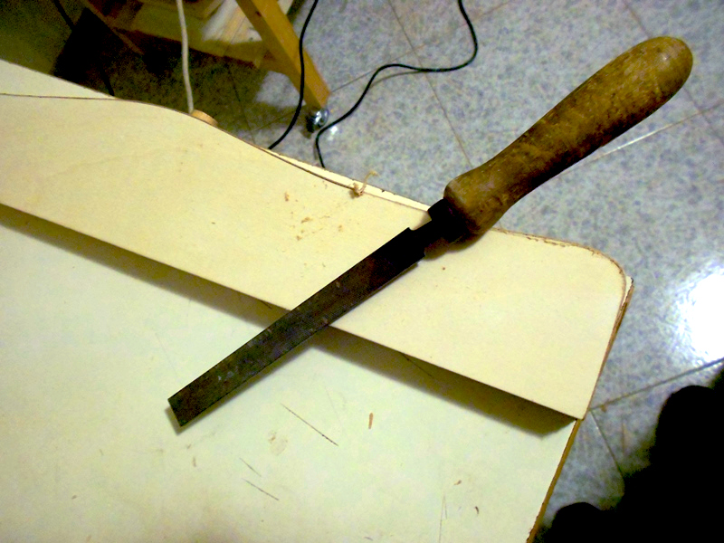 Rifilatura della parte eccedente del bordo pre-collato con una lima