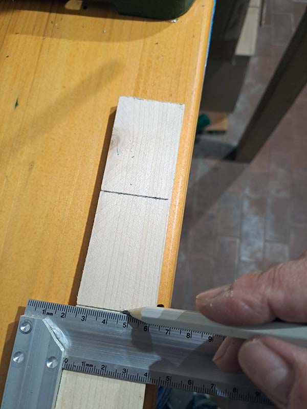 Uso una squadra da falegname per fare i segni perpendicolari come guida per il taglio